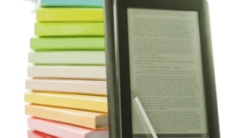 Ebook Reader vor einem Stapel Bücher